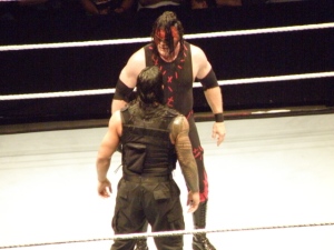 Roman Reigns stares down Kane...